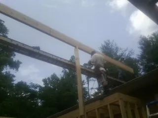 Carpenter setting a ridge beam over a new addition frame — Ice Dam Removal by Roofing Brothers in Greenfield Park