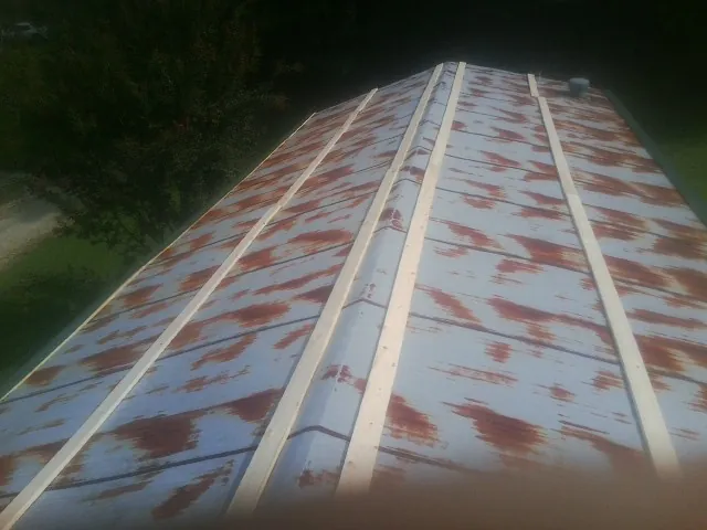 Rusted metal roof panels with new wood purlins before replacement — Storm Damage Roof Repair in Greenfield Park by Roofing Brothers